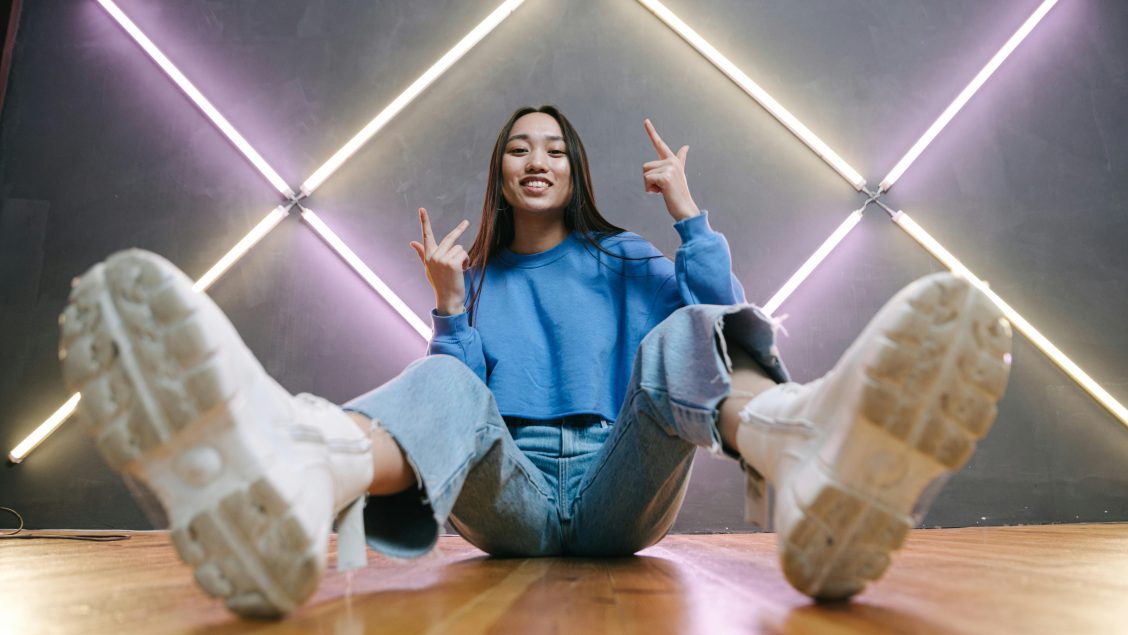 A woman in blue sweater sitting on the floor