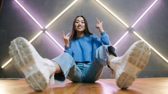 A woman in blue sweater sitting on the floor