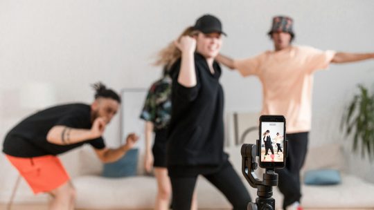 People dancing in front of a smartphone