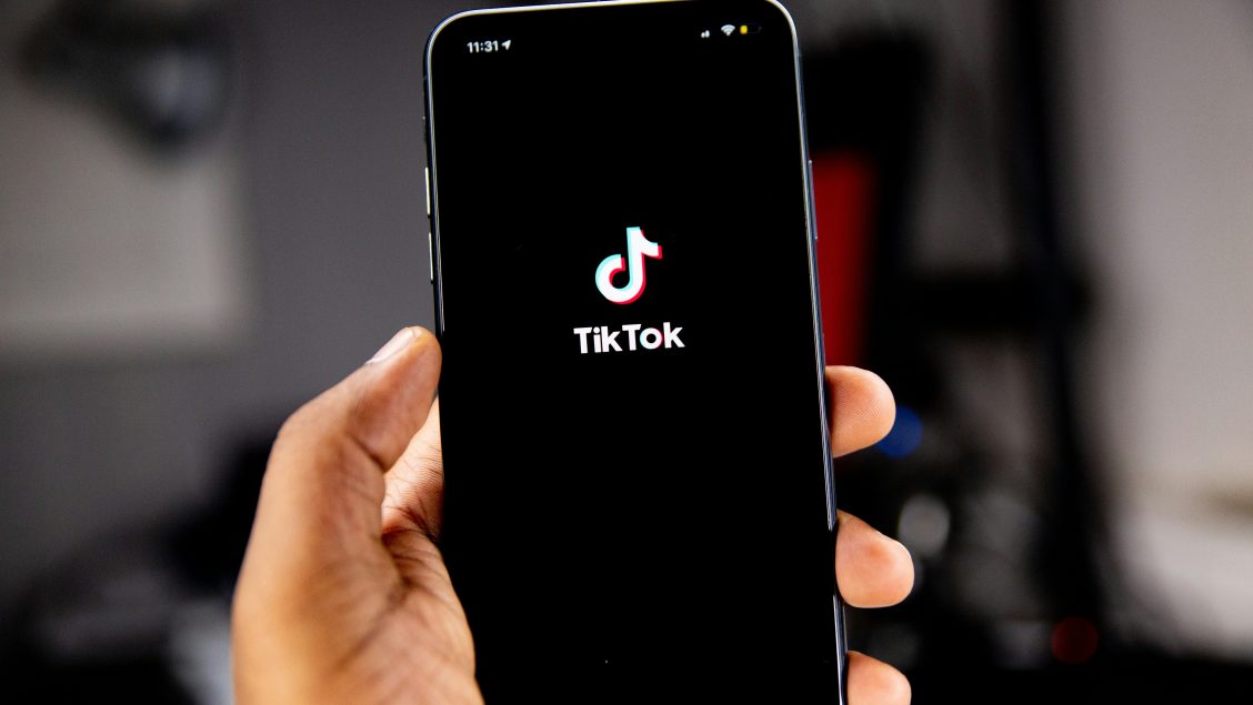 Person holding an iPhone running TikTok